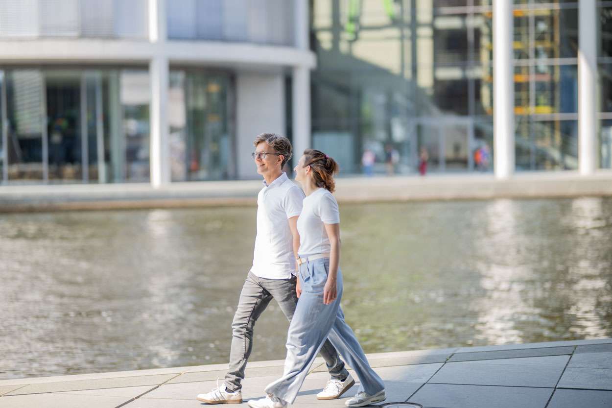 Personen spazieren am Wasser in einer Stadt.