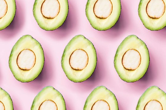 Halbierte Avocados auf rosa Hintergrund
